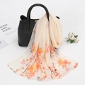 Floral print chiffon neck scarf in light cream hanging on a black leather handbag - Yellow (Artistic Grey Floral)