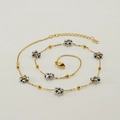 Gold stainless steel necklace featuring dark grey crystal flower beads on a white background - Necklace / White Gold