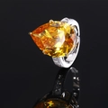 Pear cut yellow gemstone ring with pavé diamonds on a silver band shown on black mirror - Golden Yellow Zircon