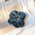Dark teal velvet scrunchie for hair with soft texture shown on a newspaper background - Lake Green