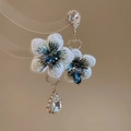Detalle de pendientes de flores de cristal con bordados azules y colgantes de pedrería - Blanco
