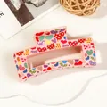 Detailed view of pink rectangular hair claw with colorful heart prints on display - 8.5cm Heart Print - Style G Pink