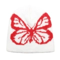 Close-up of white plush knit beanie featuring a red butterfly jacquard pattern - White