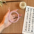 Close-up of translucent pink glass bracelet worn by a model in a traditional style setting - Pink