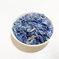 Natural blue crystal crushed stones in a white bowl for DIY jewelry and home decor - Kyanite