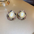 Detailed macro view of vintage cameo stud earrings with purple rhinestones and gold base - Gold-Purple-Relief Oval