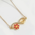Makroaufnahme von Gold-Unendlichkeitskette mit Emaille-Blume und Kristallelementen - Rote Blume