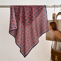 Macro detail of red paisley square scarf hanging on a metal rod with vintage props - Burgundy