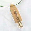 Amber resin seamless hair clip with golden metal base shown from a bottom view - Translucent Amber (C16-1-23)