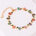 Dettaglio di bracciale dorato con ciondoli a ciliegia in smalto colorato e occhio - Bracciale Ciliegia Occhio del Diavolo