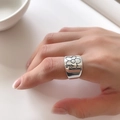 Breiter Ring aus 925er Sterlingsilber mit schwarzer Blume am Finger getragen - Silberner Blumenmuster Ring