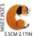 Detailed embroidery patch sizing view showing 5.2cm by 5.5cm dimensions of the dachshund dog - US 10