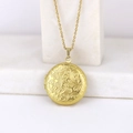 Golden round locket necklace with floral engraving resting on white marble - Plum Blossom Round/Gold