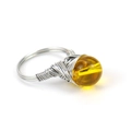 Detail showing the handmade silver wire-wrapped ring with a translucent yellow bead - Citrine
