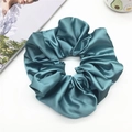 Detailansicht eines großen salbeigrünen Satin-Haargummis mit glatter Faltenstruktur - 20cm / Türkisgrün
