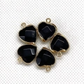 Detailed view of five black heart-shaped stone pendants with gold-plated metal borders - 15x18mm / Black Agate