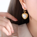 Boucles d'oreilles cœur en perle vintage avec cadre doré portées sur un modèle - Style de Coeur Blanc Doré (F898)