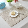Macro detail of French cotton linen placemat with vintage newspaper print and lace edge - Alphabet