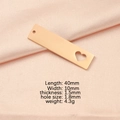 Makro-Detail von goldenem Edelstahl-Rechteckanhänger mit Herz-Ausschnitt und Maßen - Roségold