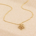 Collana con ciondolo a fiore dorato e cristalli brillanti su sfondo minimalista materico - Stile Fiore a Cinque Petali/Stella / Oro