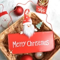 Red metal Merry Christmas sign with Santa Claus and tree hanging on a rustic basket - Red