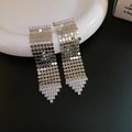 Gros plan sur des boucles d'oreilles à franges en maille argentée avec strass brillants - Gland en Maille de Zirconia Triangle (54#)