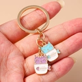 Cartoon potted cat keychains in gold finish featuring purple and blue kitten pendants - Potted Cat