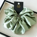 Macro detail of high-quality light green satin oversized scrunchie with handmade tag - 18cm / Cardamom Green