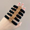 Five black high-elastic hair ties with brown cartoon bear tags shown on wrist - Set of 5 / Black