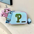 Light blue crossbody bag with letter P patch, pink trim, and wide patterned shoulder strap - Blue