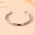 Detailed view of silver stainless steel bangle with elegant twisted design and glossy finish - Steel Twisted Style (S506)