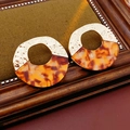 Detailed view of gold and amber tortoise shell earrings on a vintage wooden frame - Gold Spliced Amber (WE4786)