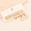 Close-up of golden earring set with Hamsa hand, evil eye and sparkling rhinestones - Hamsa Hand and Evil Eye (9# Eye)