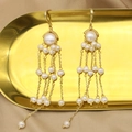 Elegant gold-tone tassel earrings featuring multiple white pearls on a metallic tray - Palace Tassel Style