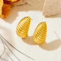 Macro detail of gold earrings featuring spiral texture and brushed metal finish - Chrysalis Style (23991)