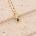 Detailed shot of golden bear pendant with blue heart crystal on a textured stone plate - Full Zircon Dark Blue Heart Bear (13#)