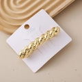 Detail of twisted gold metal hair clip with vintage spiral texture on a display card - Spiral Hammered Gold