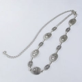 Macro shot of silver bohemian waist chain with vintage embossed floral metal plates - Silver