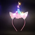 LED unicorn headband with silver horn, sequins, and tulle in a glowing dark setting - LED Unicorn Silver Horn