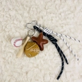 Detail of baseball keychain with mini bat, ball, glove, and braided rope on soft carpet - Charm / Baseball Glove Brown Star