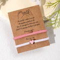 Rosa und weiße geflochtene Herzarmbänder für Paare auf einer dekorativen Grußkarte - Freundschaft Kraftpapier-Karte / Rosa & Weiß Set