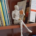 Detailansicht einer Lesende Frau Skulptur aus Harz mit Zeitungstextur auf dem Regal - Lesende Frau 02