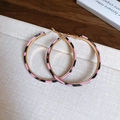 Close-up of pink and black leopard print hoop earrings with golden metal accents - Silver Earring Post - Gold - Pink