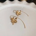 Detail of vintage gold iris flower earrings with textured petals on a ceramic dish - Gold
