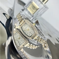 Close-up of tonneau emerald quartz watch with crystal bezel on reflective tray - Two-tone White Dial
