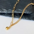Detailed view of asymmetric gold chain necklace featuring a polished solid metal ball pendant - Gold