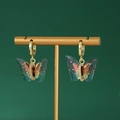 Pendientes de mariposa en acero de titanio con alas de purpurina sobre soporte dorado - Par de Pendientes / Colorido