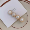 Elegant gold-tone hair clip featuring four large white faux pearls on a flat lay display - 4-Pearl Duckbill Clip