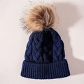Detail view of navy blue cable knit winter hat with a brown faux fur pom pom - One Size / Navy Blue