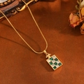Detail view of perfume bottle pendant with emerald and zircon checkerboard on snake chain - Gold Green Checkerboard White Zirconia